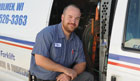 employee smiling at door of service vehicle